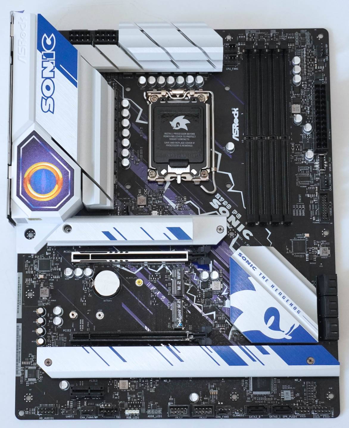 主板以黑色为基调，搭配白色与蓝色散热片。